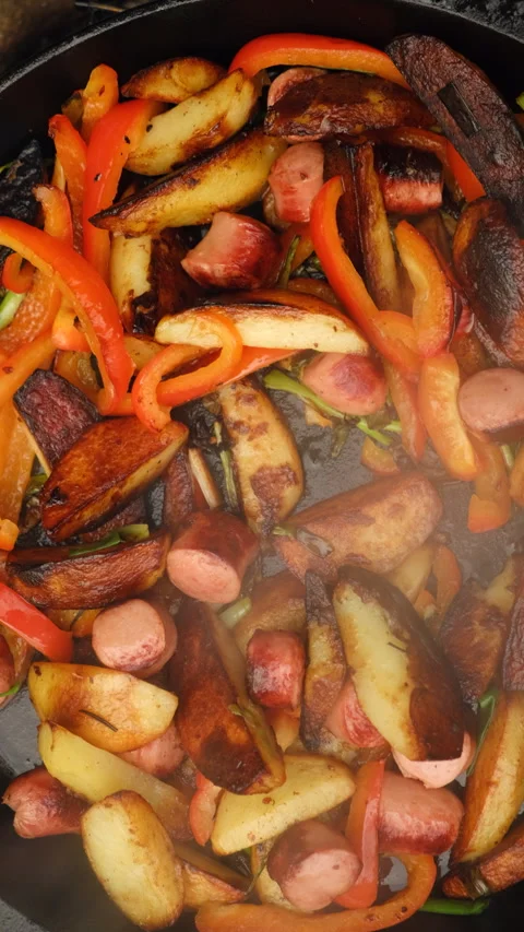 Vertical footage of cooking dish with potatoes and vegetables on campfire Stock Footage 297961702