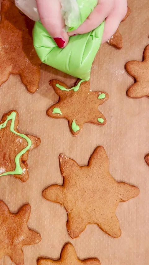 Vertical footage of decorating Christmas gingerbread cookies with green icing Stock Footage 208157182