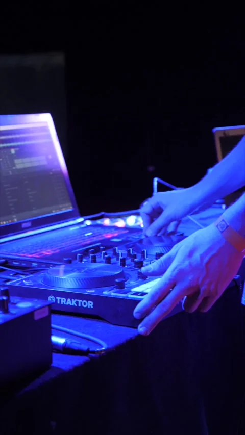 Vertical footage of a DJ playing on turntable in nightclub under blue neon light Stock Footage 219990523