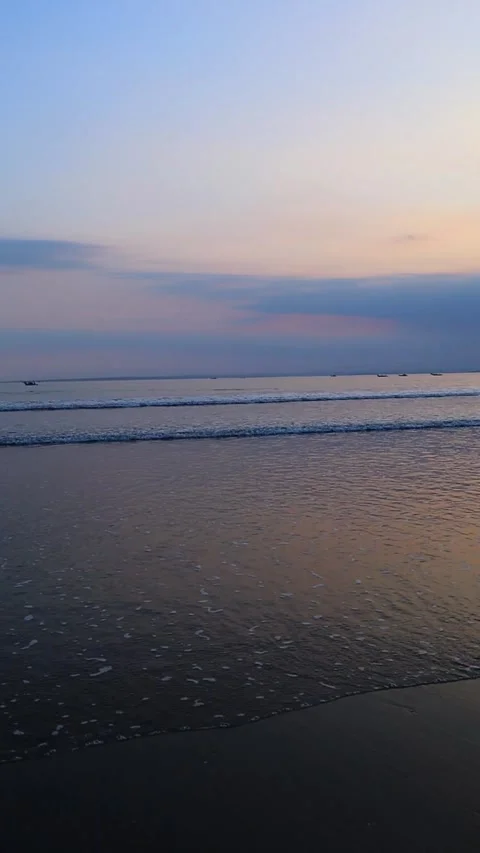 Vertical Footage of Gentle Waves on a Calm Beach at Dusk with Pastel Sky 스톡 동영상 343810528