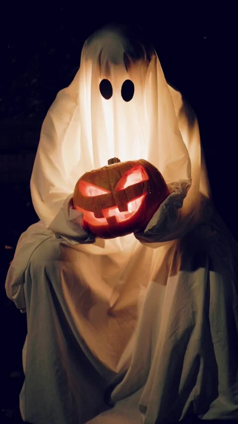 Vertical footage of glowing ghost holding carved pumpkin for Halloween. The illu Stock Footage 346723199