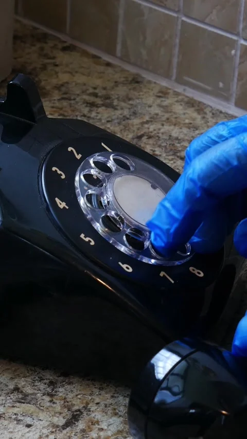Vertical Footage of Hand makes call on rotary dial phone with blue latex glove. Stock Footage 235870712