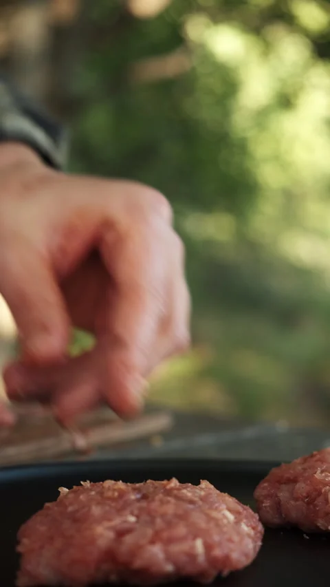 Vertical footage of man makes cutlets from minced meat for burger at outdoors Stock Footage 286308905