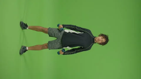 Vertical Footage. Motivated Man Doing Exercises with Dumbbells Raising Hands Up Video stock 219730381