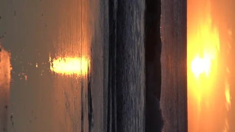 Vertical footage of ocean sunset on sandy beach and sunny path on water surface. Stock-Footage 240188923