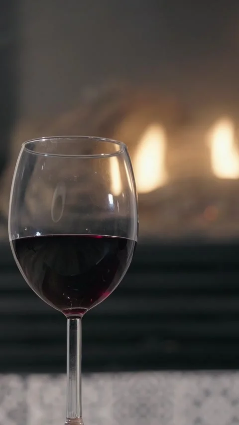 Vertical footage of red wine in front of a fireplace Stock Footage 333669759
