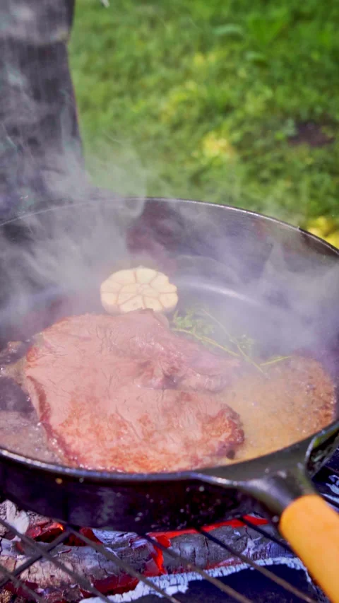 Vertical footage. Steak is being cooked in a wine and butter sauce. Stock Footage 317932654