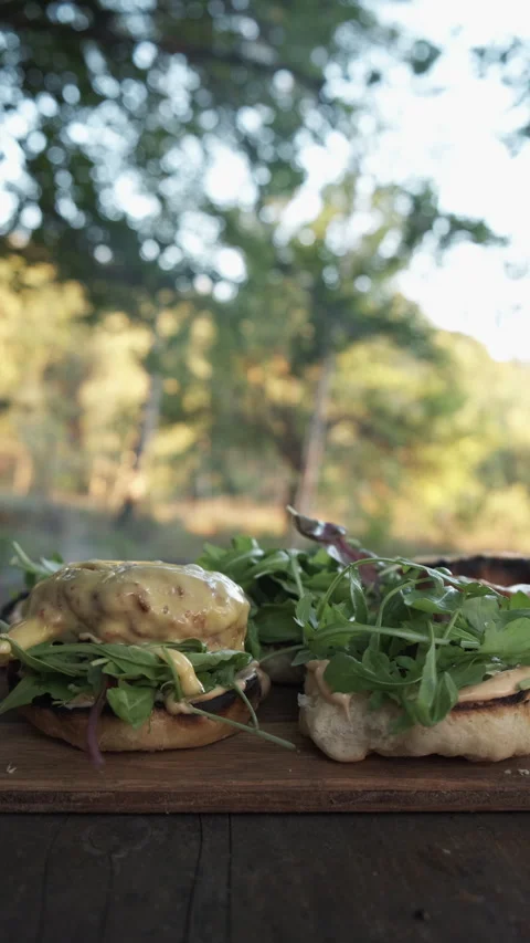 Vertical footage of unknown man making tasty burger in autumn forest Stock Footage 286312962