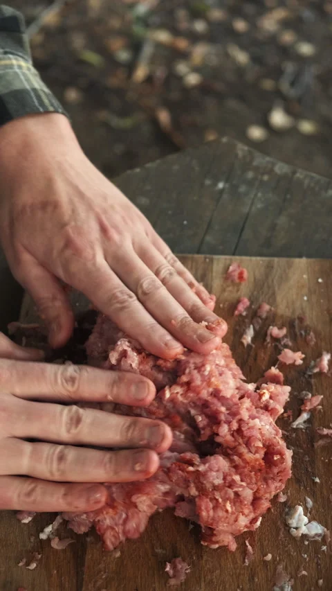 Vertical footage of unknown young man prepares minced meat with hands for kebab Stock Footage 286314513