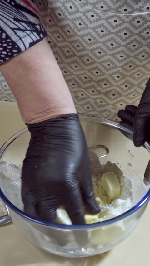 Vertical footage. A woman's hand add butter into a glass bowl to make cookies. Stock Footage 299634834