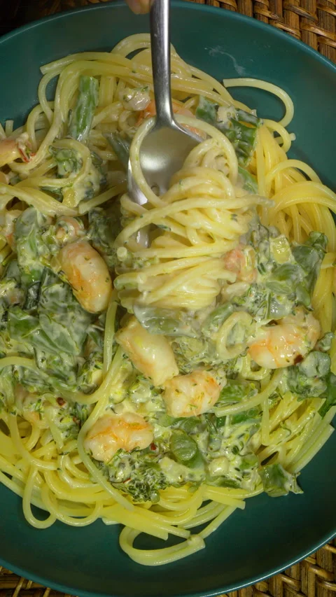 Vertical- A fork turning to lift spaghetti from a bowl with prawns and broccoli. Vídeos de archivo 288461422