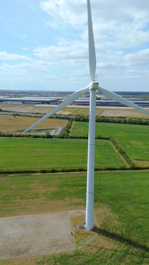 Vertical format aerial drone view of wind turbine generating renewable energy Stock Footage 317073183