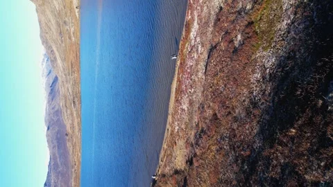 Vertical format aerial orbits lakeside hiker on colourful arctic tundra Stock Footage 318727969
