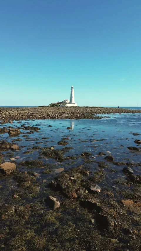 Vertical format Low Drone Flyover Towards St Mary’s Lighthouse at Whitley Bay Stock Footage 327334419