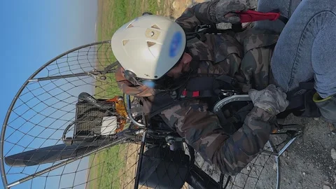 Vertical format: Paramotor pilot straps himself into harness to fly Vidéo 262306820