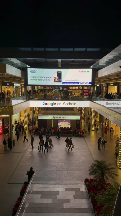Vertical-format shot of a mall displaying major brands on a large LED screen Stock Footage 325475016