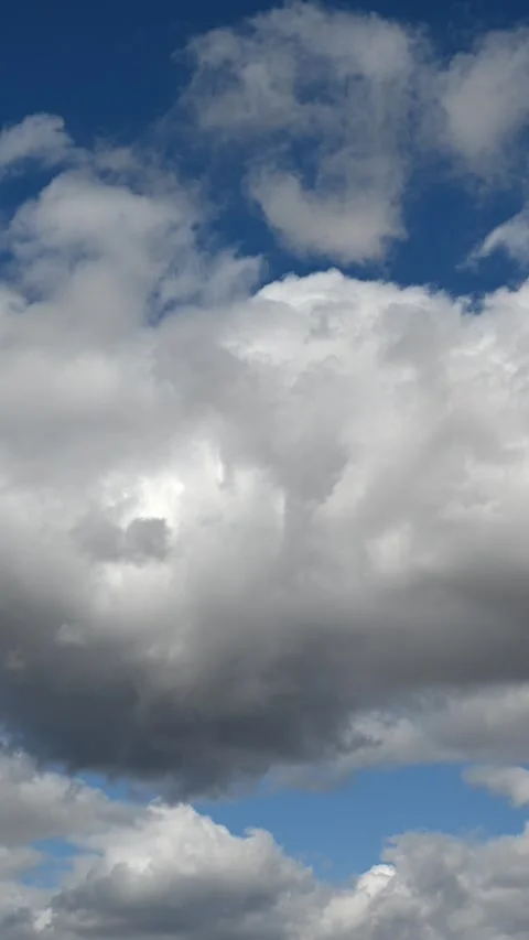 Vertical format time lapse of white summer clouds moving in a blue sky Stock Footage 286903621