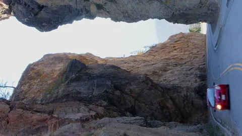 Vertical format timelapse: Cars drive through narrow rock canyon Stock Footage 319076597