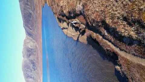 Vertical format trekkers hike along arctic lake on Greenland tundra Stock Footage 318727892