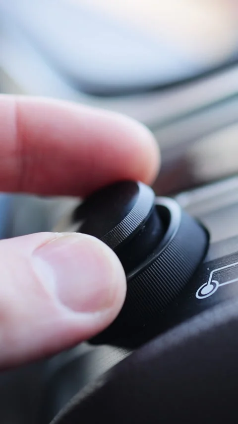Vertical Format Video of Car dashboard volume knob. Driver's hand adjusts volume Stock Footage 306764371