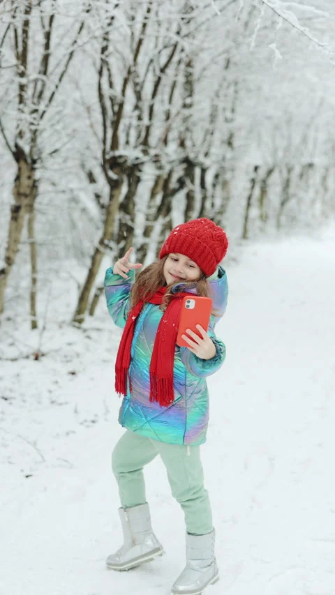 Vertical Format Video of Cute little girl taking a selfie in the winter forest Stock Footage 304910423