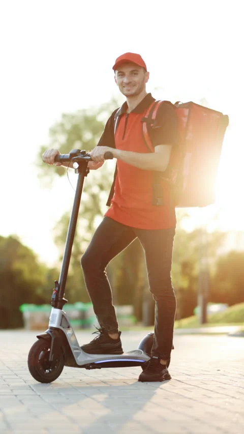 Vertical Format Video of deliverman standing with electric scooter with red Stock-Footage 304175748