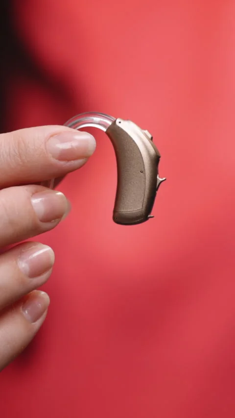 Vertical Format Video of Female hand holding a hearing aid on an outstretched Stock Footage 305787662