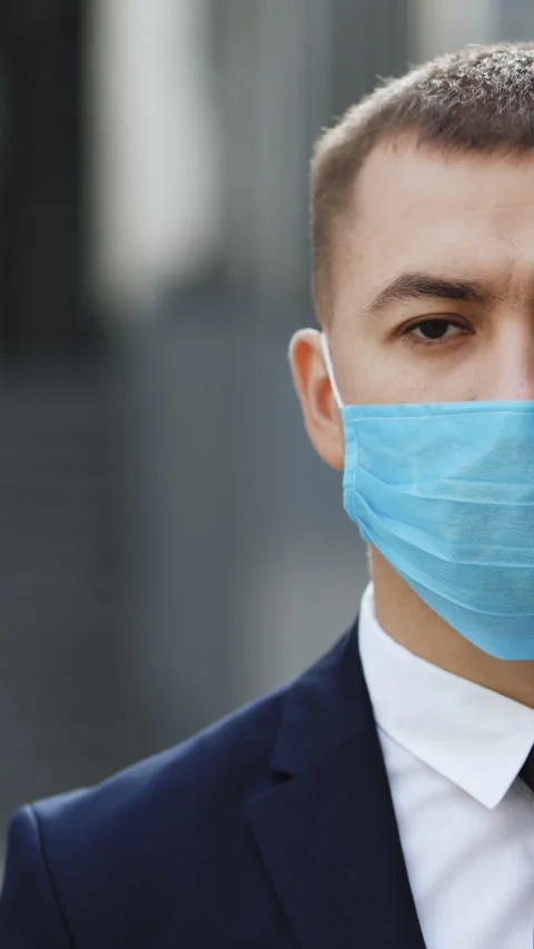 Vertical Format Video of half face of upset handsome man in medical mask looking Stock Footage 302804613