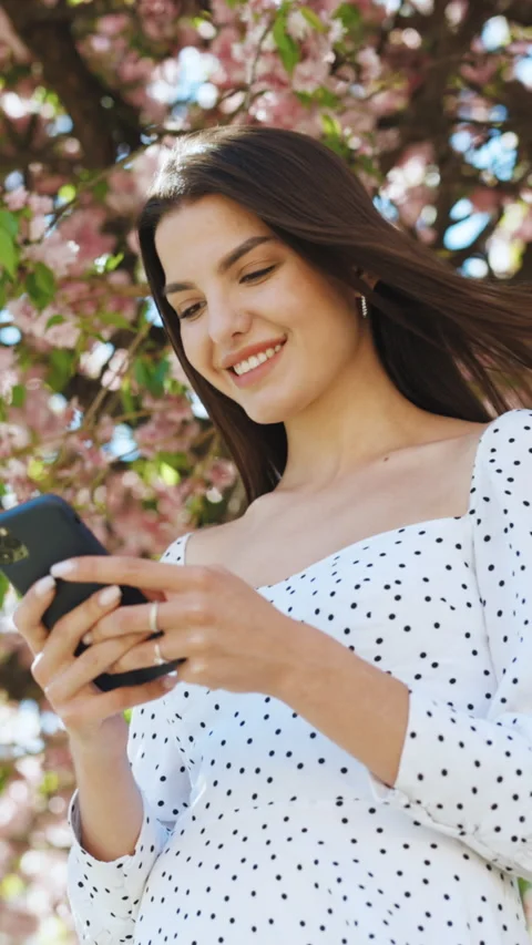 Vertical Format Video of happy hipster woman typing by mobile phone outdoors Stock Footage 304671305