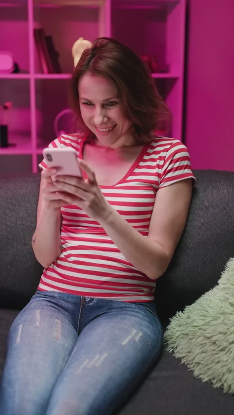 Vertical Format Video of Happy Relaxed Young Woman Holding Smart Phone Looking Stock Footage 303360579