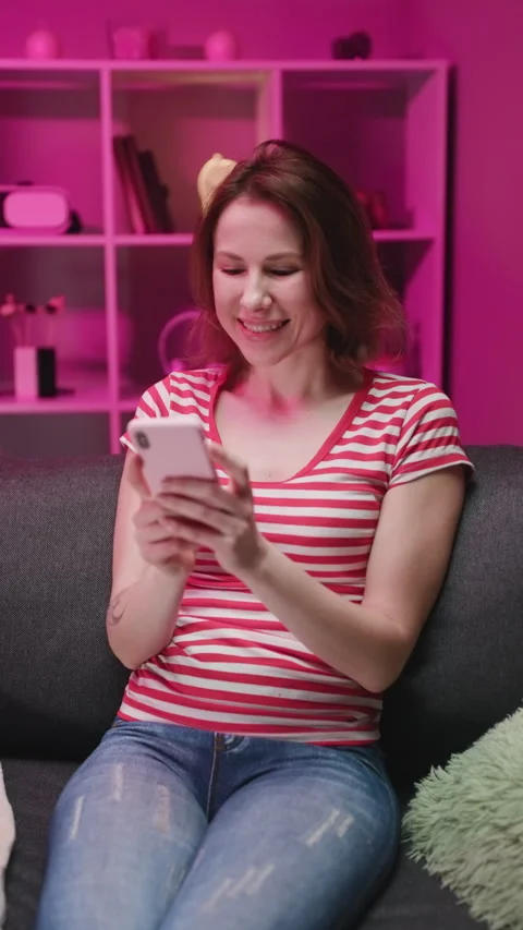 Vertical Format Video of Happy Relaxed Young Woman Holding Smart Phone Looking Stock Footage 303364778