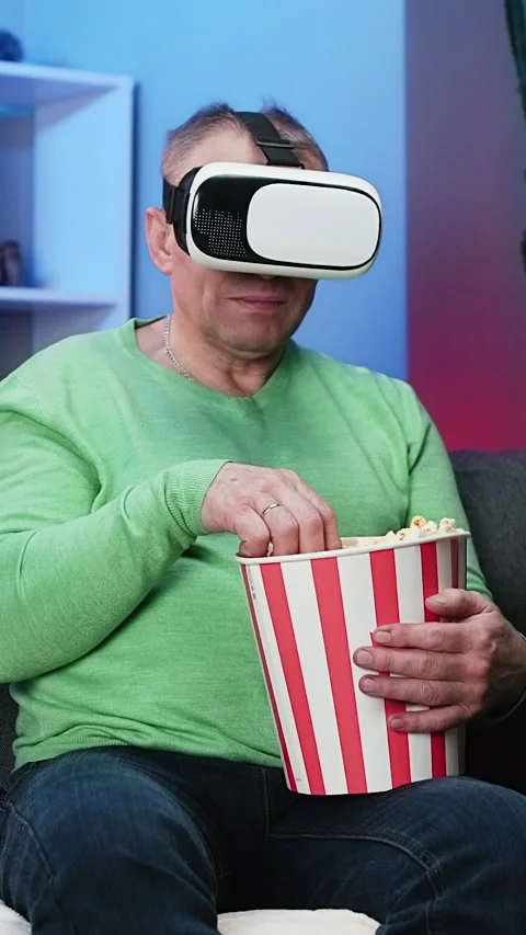 Vertical Format Video of locked shot senior man sitting on Sofa and holding Stock Footage 303139948