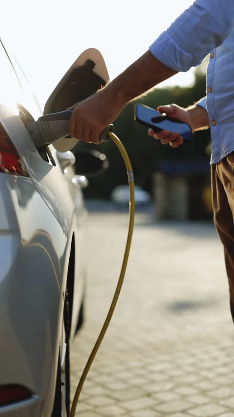 Vertical Format Video of man unplugging electric car cable. Guy stopping Stock Footage 306093882