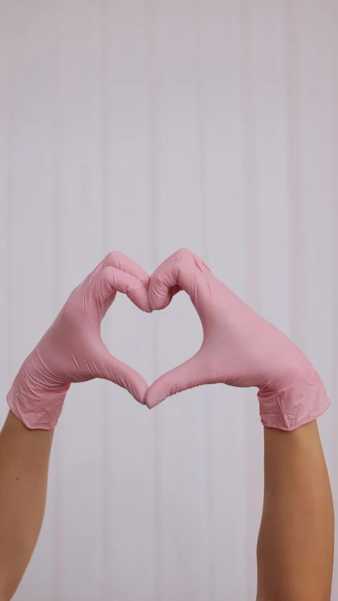 Vertical Format Video of person in pink latex gloves showing heart gesture Stock-Footage 306310413