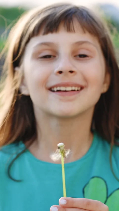 Vertical Format Video of Portrait of a beautiful young girl blowing on the Stock Footage 305472114