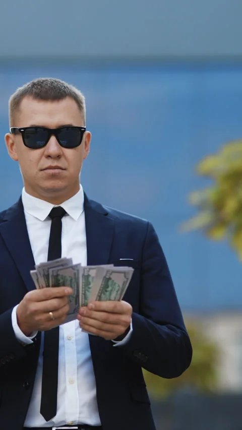 Vertical Format Video of Rich man in stylish suit wearing sunglasses counting Stock Footage 302805941