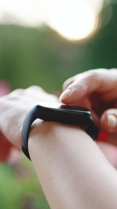 Vertical Format Video of Smart watch on female wrist. Girl check pulse on Stock Footage 303973432