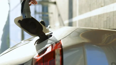 Vertical format video of unrecognizable female unplugging electric car cable Stock Footage 200962358