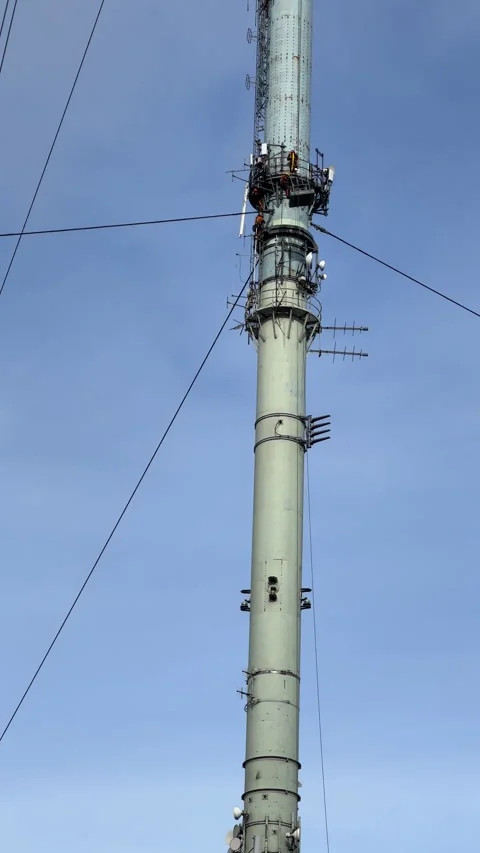 Vertical. Four tower climbers working high up on telecommunications mast. Stock-Footage 329125811