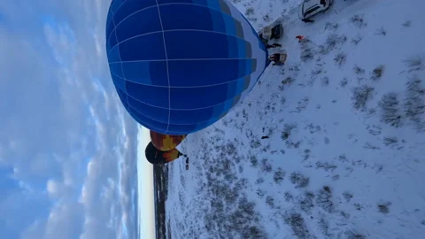 Vertical FPV Aerial View of Hot Air Balloons Preparing to Take of in Snowy Stock Footage 195101799