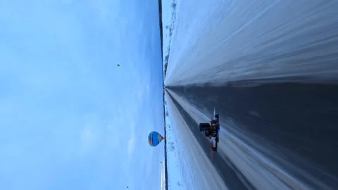 Vertical FPV Aerial View, Tracking Another Drone Flying Above Icy Road on Stock Footage 194554780