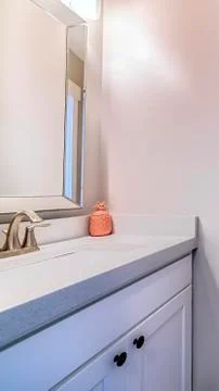Vertical frame Bathroom interior with view of sink cabinets wall mirror lights Stock Photos