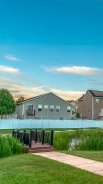 Vertical frame Bench facing a pond with bridge and view of family homes in the Foto stock