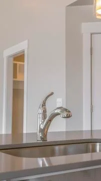 Vertical frame Close up of the clean and shiny sink inside the kitchen of a new Stock Photos