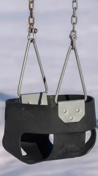 Vertical frame Close up on an empty swing in a playground Stock Photos