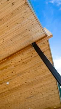 Vertical frame Close up view of the underside of the roof of a house with blue Stock Photos