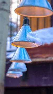 Vertical frame Cone shaped string lights with snow hanging outside a home in Stock Photos