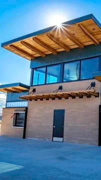 Vertical frame Facade of building with flat roof and brick wall against blue sky Foto stock