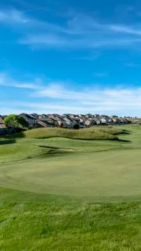 Vertical frame Golf course with view of lovely homes and mountain under blue sky Stock Photos