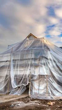 Vertical frame House under construction covered with plastic against mountain Stock Photos